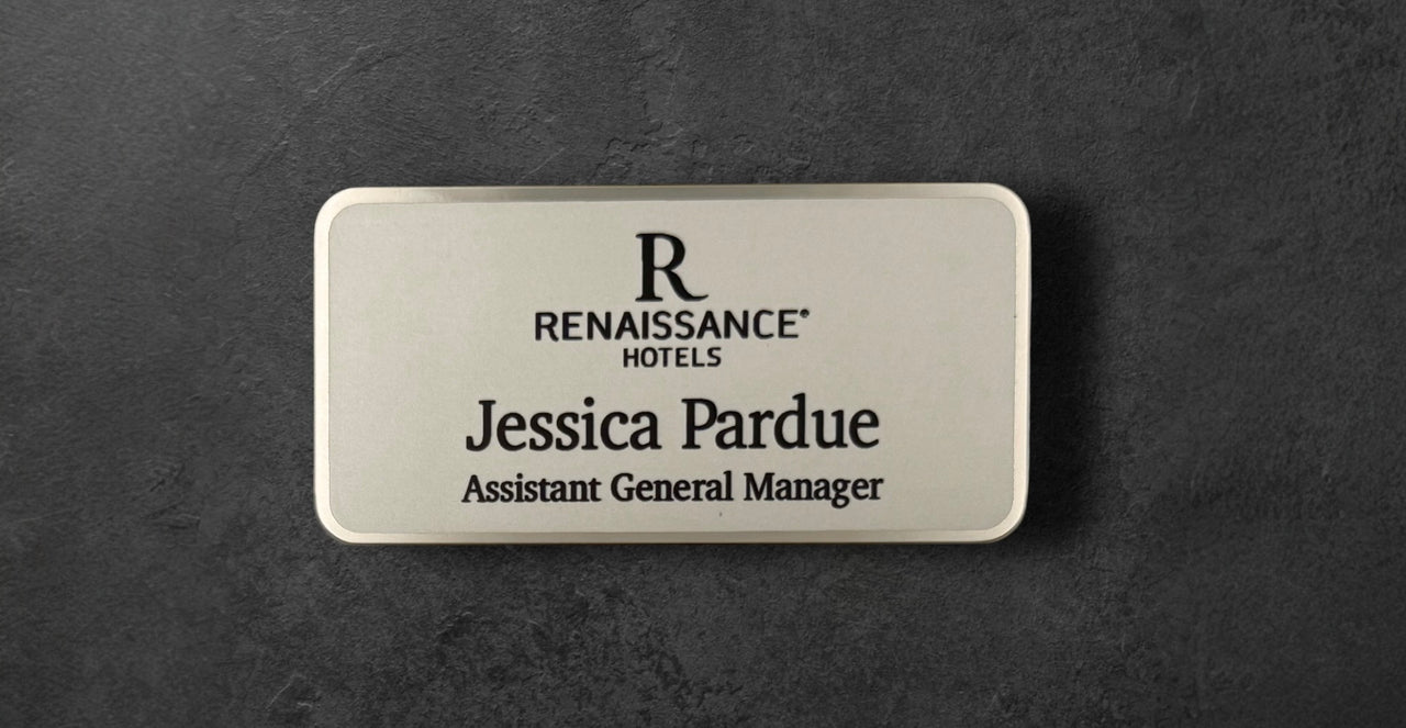 Silver Renaissance Hotels name tag with logo and text