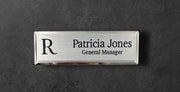 Silver metal beveled name tag with a brushed silver metal face, with logo, name and title
