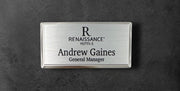 Silver metal beveled name tag with a brushed silver metal face, with logo, name and title, 1.5" x 3"