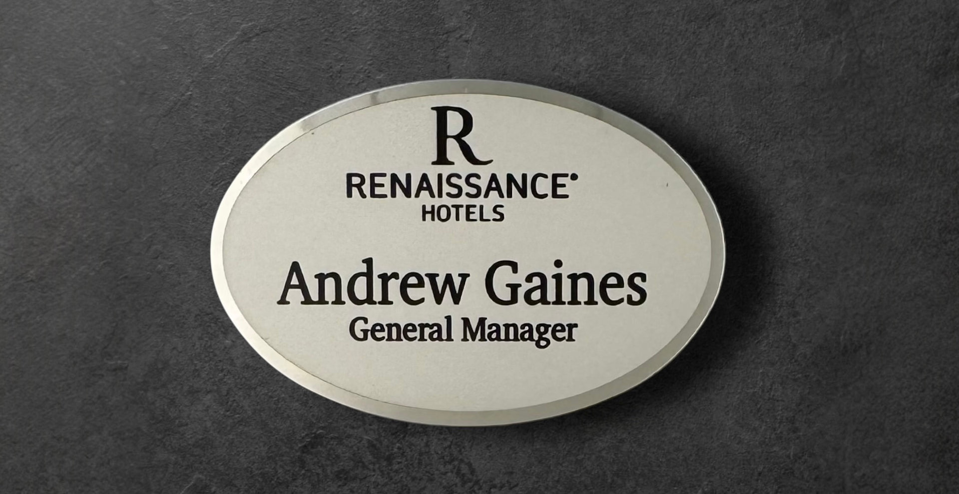 Renaissance Hotels name tag in silver metal with logo on top, name and title underneath